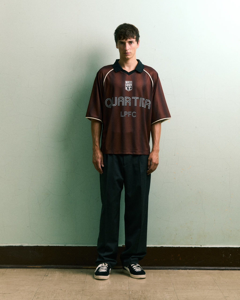 Model wearing LE PÈRE LPFC Football Jersey in brown stripe with minimalist styling.